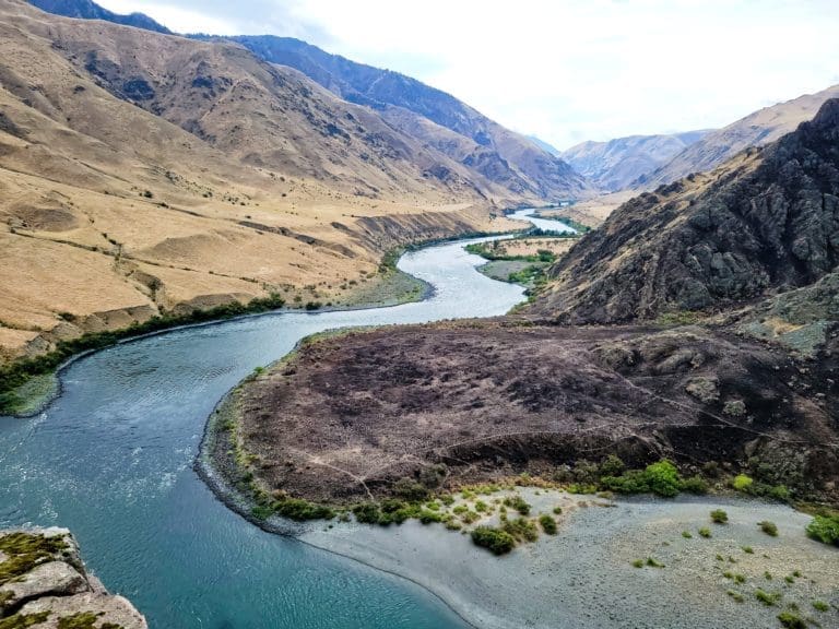 Overhead picture of a calm river winding through a rocky canyon.