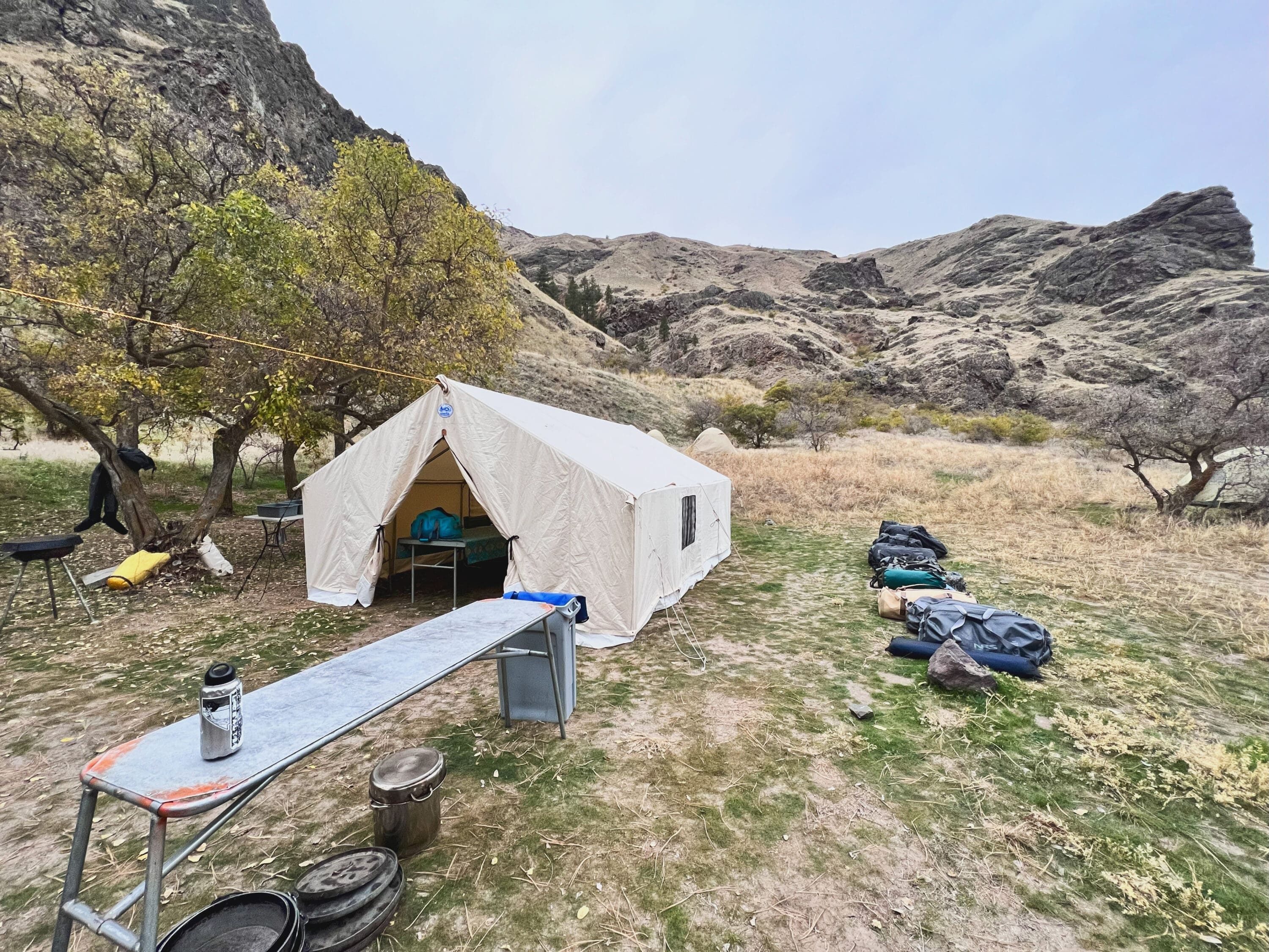 Glamping style canvas tent with mountains in the background.